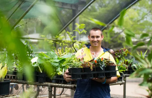 Student holding a tray of plants