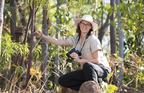 Alyson Stobo-Wilson with binoculars in bush