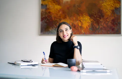 Yuliia Shchedrovska writing at a desk / working from home