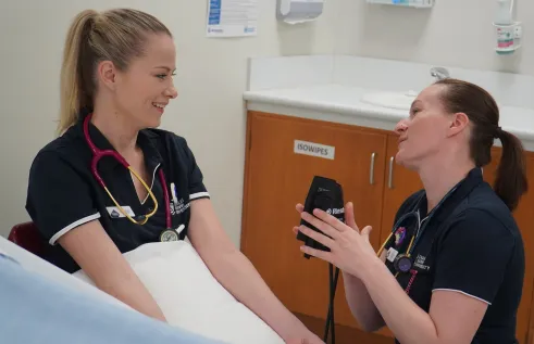 alicia burrows getting heart rate checked by coworker