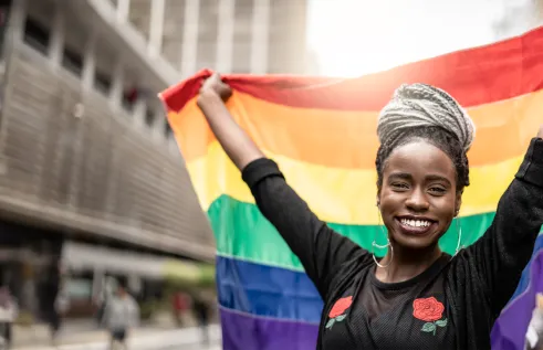 African american woman holding a pride flag 