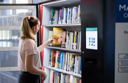 CDU student Zoe White using a book vending machine