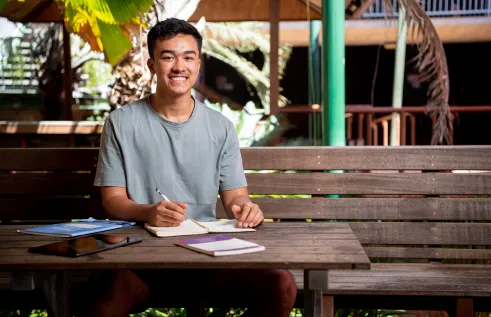 Student sitting with notes and textbooks