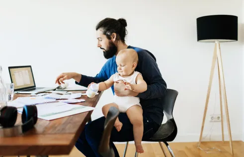 Father studying with baby on his lap