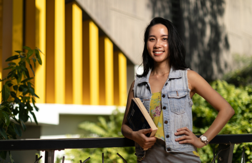 MBA student Ellie holding book on campus