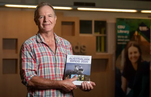 CDU Conservation Professor Stephen Garnett with the Action Plan for Australian Birds 2020 book he edited that identified 216 threatened birds in Australia.