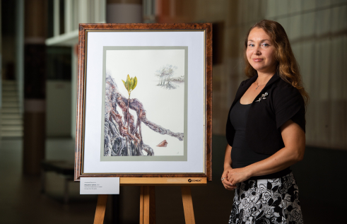 Anastasia Maksimova with the Spotted Mangrove botanical painting that is being exhibited in Kew.