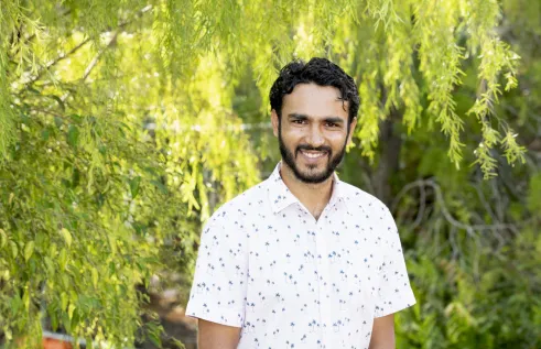 Dr Manoj Bhatta head and shoulders with green leafy background