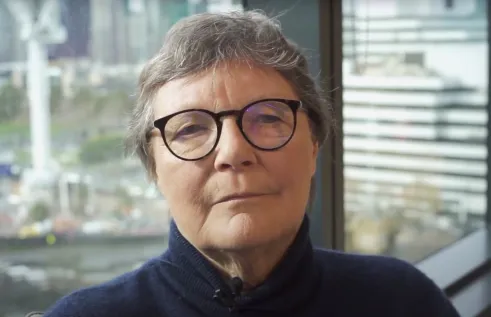 Researcher Helen Verran sitting inside against window for interview