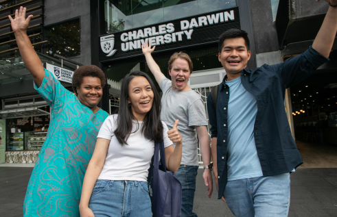 four students posing in front of CDU Sydney campus