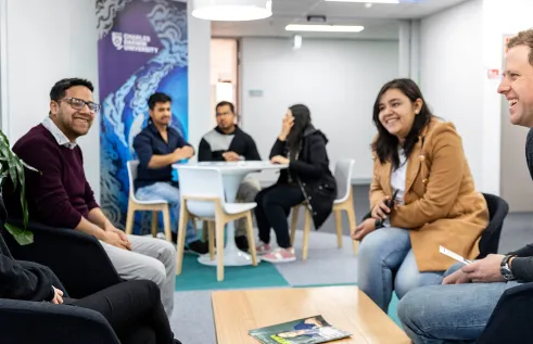 A group of students sitting around a table at Sydney campus