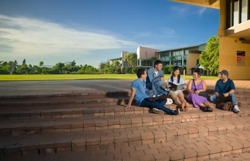 group of students sitting in front of the strand