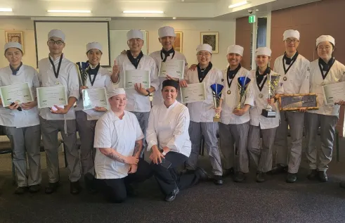 Competitors and judges pose with certificates