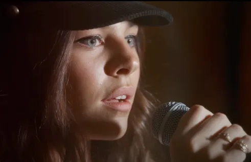 young women sings into microphone