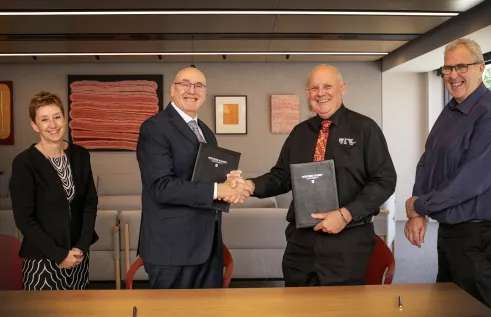 two men shaking hands in boardroom