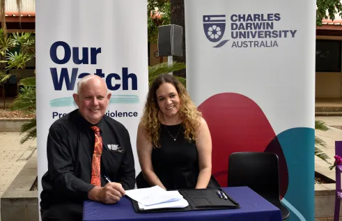 man and women pose in front of banners