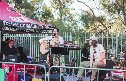 singer with guitar and drummer on stage