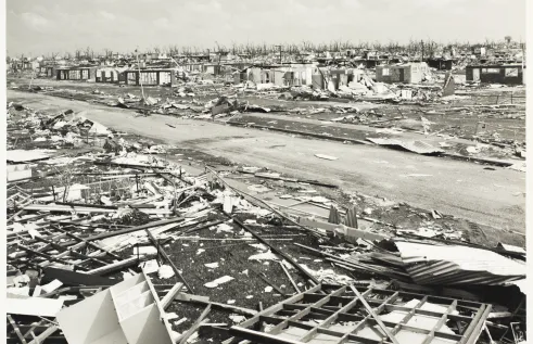 Black and white photo of destroyed houses after Cyclone Tracy hit a suburb of Darwin. 