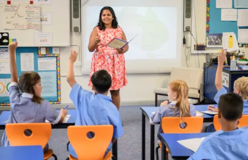 Indigenous woman teaches children in a classroom