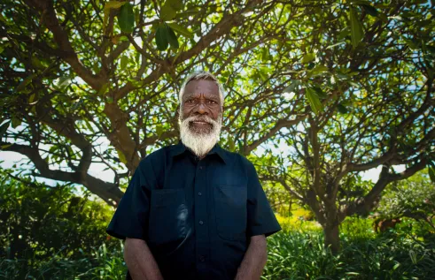 Elder stands in front of tree
