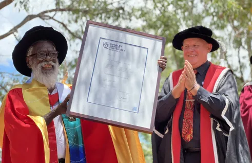 Dr Yibarbuk holds his PhD proudly