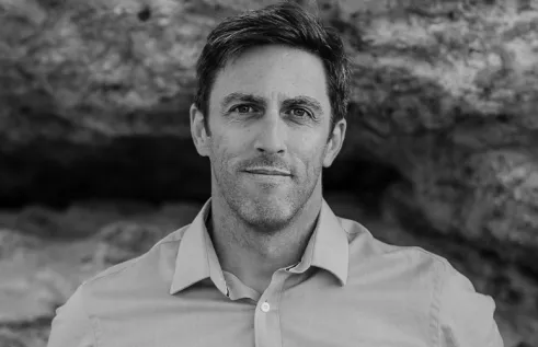 Author Russell Marks against rockface in black and white