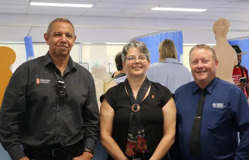 Three people pose in health facility