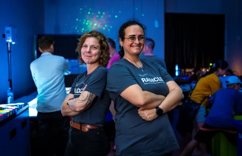 two people stand in dark room with glowing lights
