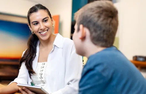 Social work student sitting with a child