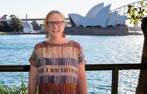 person poses in front of Sydney harbour