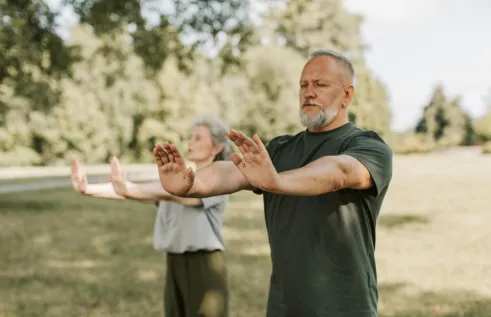 two people practicing tai chi outdoors