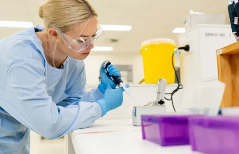 Image of a girl in a medical lab holding a pippet