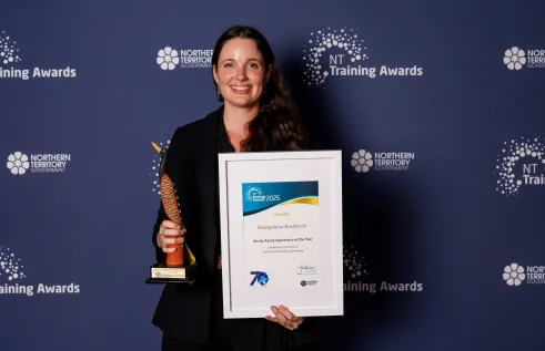 Evie stands with award