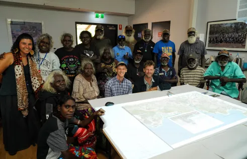 Sam Williams and Rohan Fisher (centre) with Maningrida Elders who supported the map. The model combines 3D technology and video to create an interactive map filled with traditional knowledge and stories. Credit: David Mason