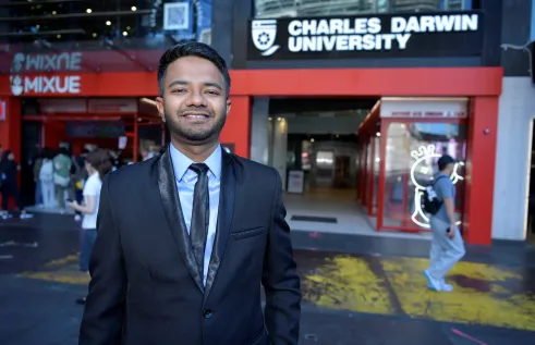 Jabir standing in front of CDU sign 