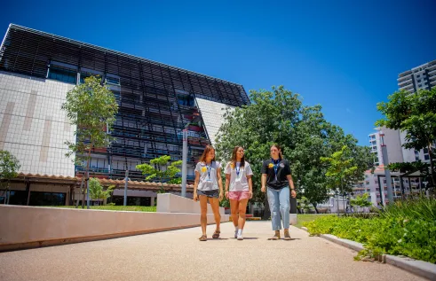 Three students walking with Danala | ECP building in the background