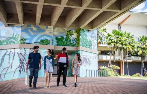 Four students walking around the Casuarina campus