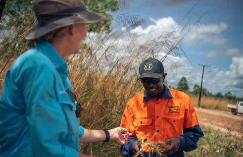 Lecturer hands native grass to First Nations student 