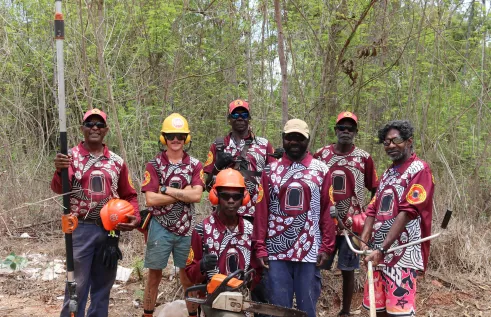 RAC workers stand in front of Coffee Bush weeds