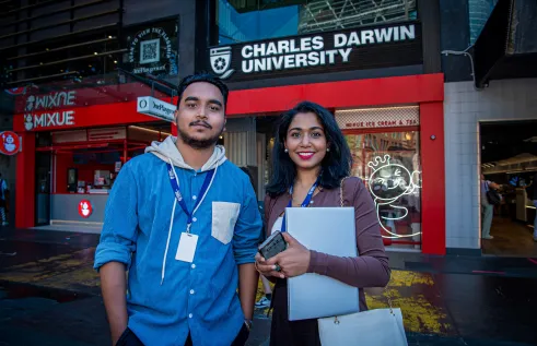 students stand in front of campus entrance