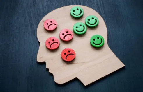wooden head with sad and happy smileys