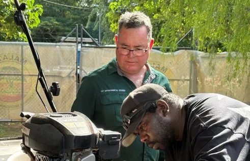 Lecturer with student fixing a lawn mower