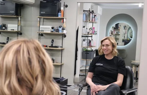 Esme sits in barbering chair
