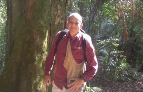 Dr Mochamad Indrawan walking in the bush with trees in the background