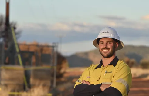 Male tradesperson standing in front of power lines