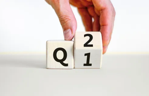 photo of two blocks with q and 1/2 written on it which a hnd grabbing one cube