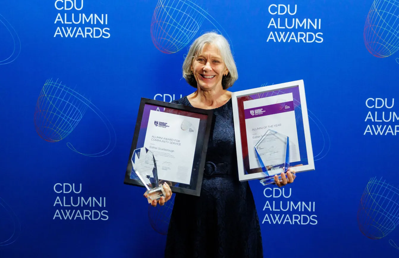 Esther stands with her two awards and certificates