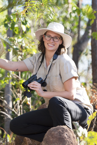 Alyson Stobo-Wilson holding binoculars in bush