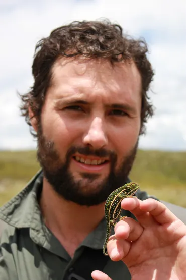 Tom Duncan head and shoulders, with hand holding small lizard