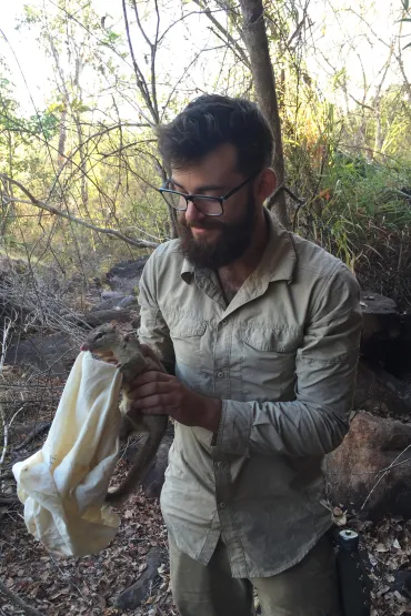 Gavin Trewella holding a quoll in the bush